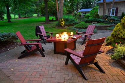 LFP51R Lumin Fire Pit 51 inch Rectangular on brick patio at dusk with red Adirondack chairs
