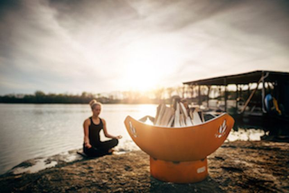 Firepit Art fire pit bowl with roaring fire at lakeside sunset